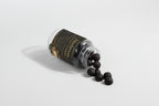 Black capsules spilling out of a transparent container with a black label on a light gray background.