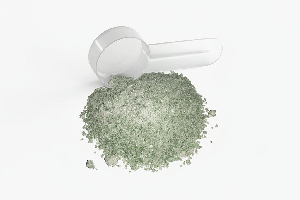 White powder shaker with green powder on a white background