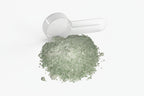 White powder shaker with green powder on a white background