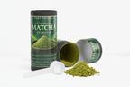 Ceremonial matcha powder container with open lid and scoop on a white background